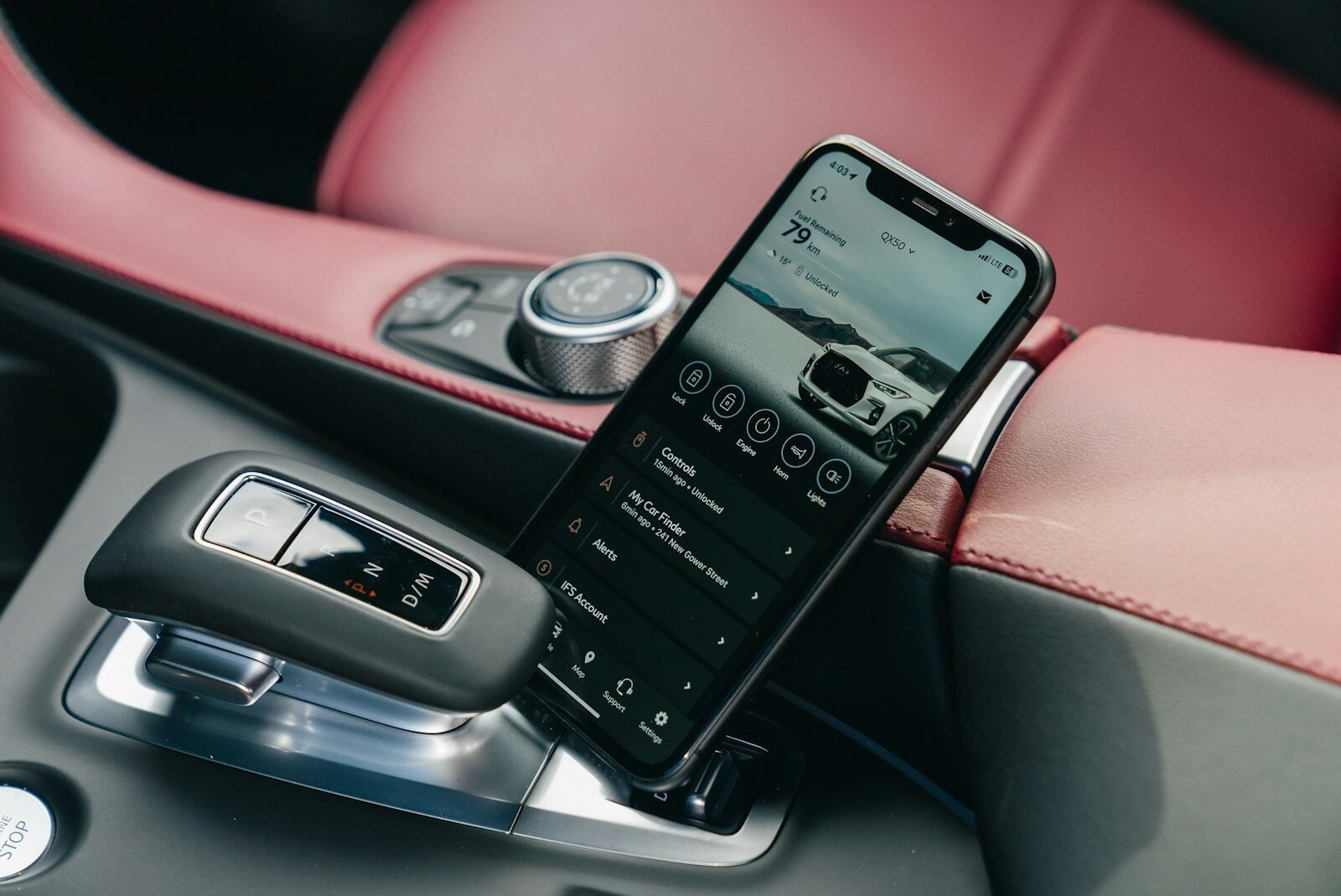 Smartphone displaying car interface in car console.