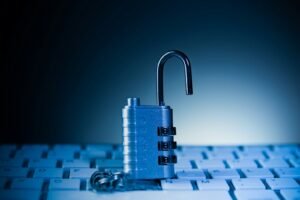 An unlocked padlock rests on a computer keyboard.