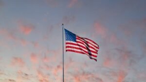 us a flag on pole under cloudy sky